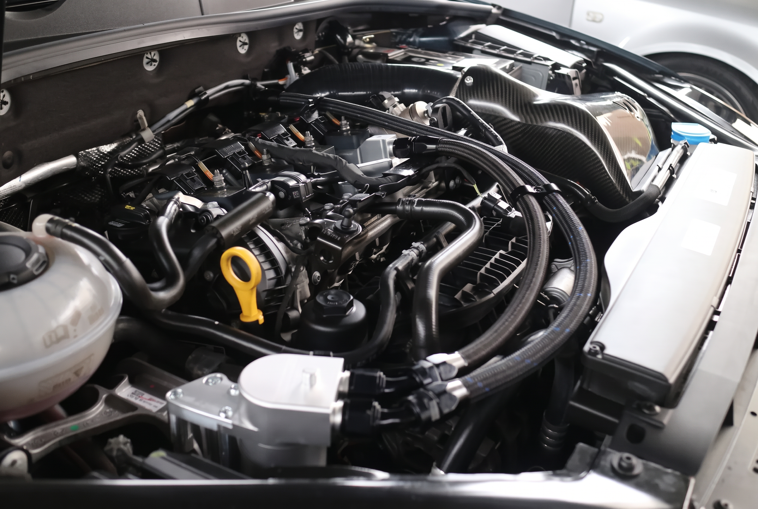 Modified engine bay with carbon fiber intake and braided lines