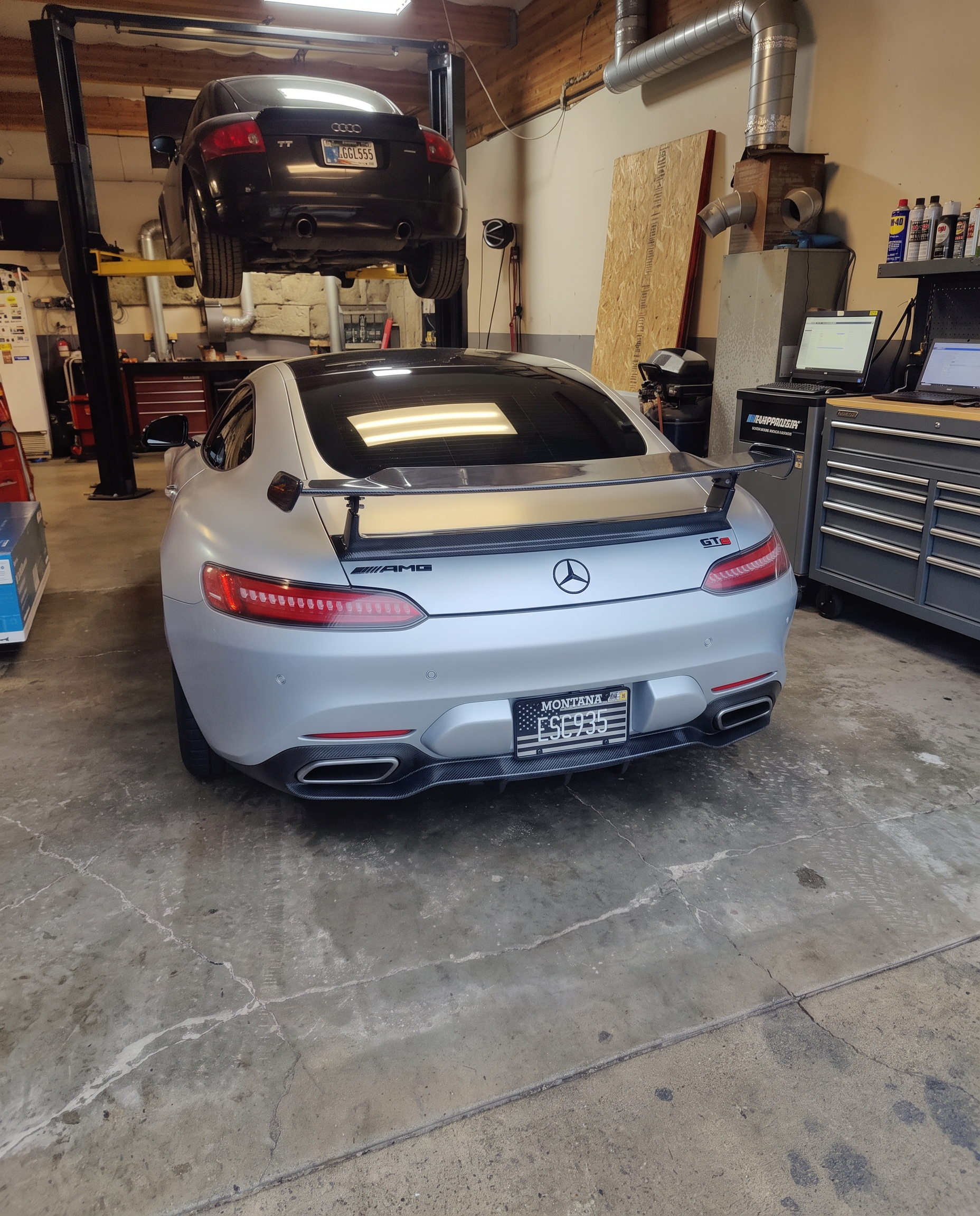 Silver Mercedes-AMG GT S with carbon wing in the shop, Audi TT on the lift behind