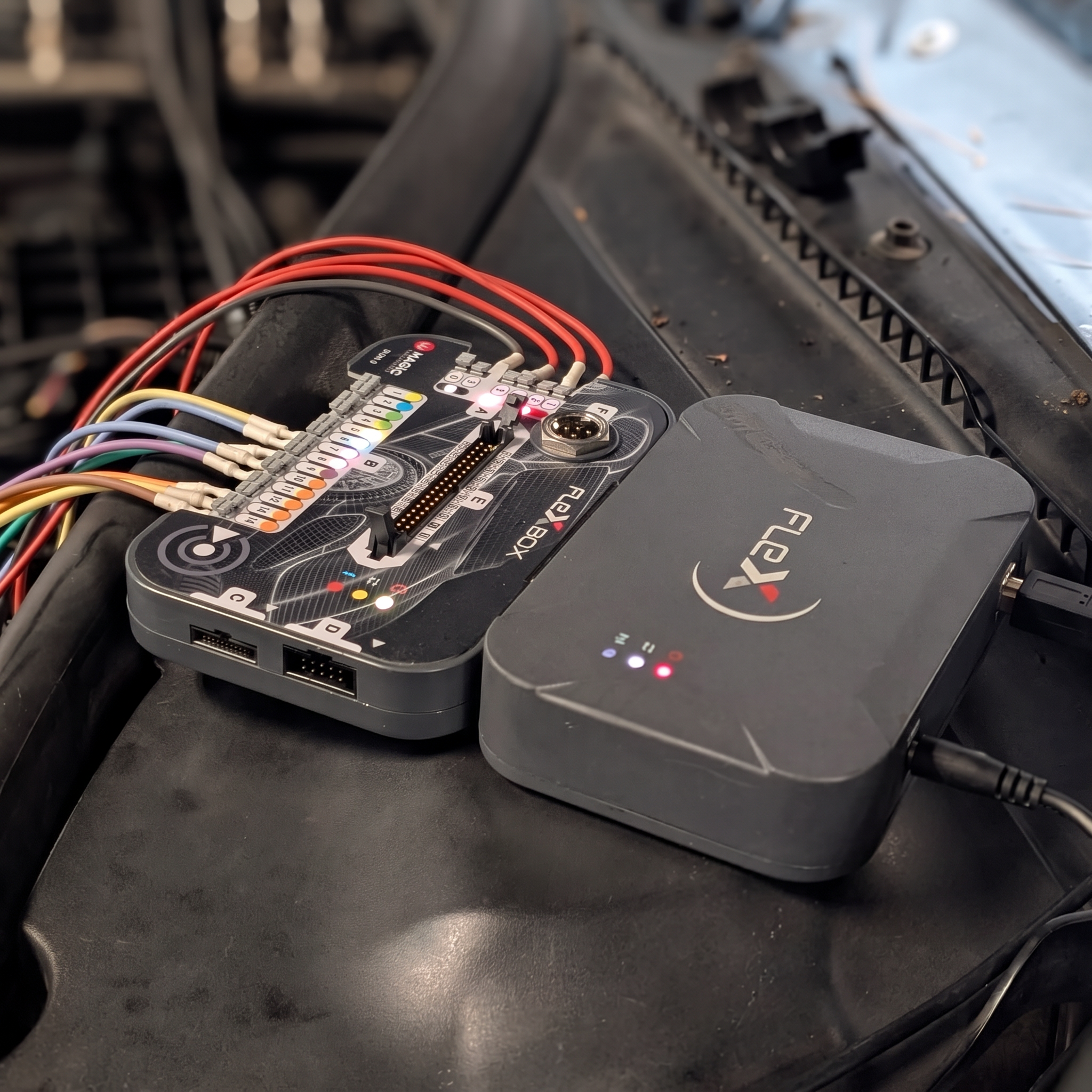 Magic FlexBox and FlexX ECU flashing tools wired into an engine bay