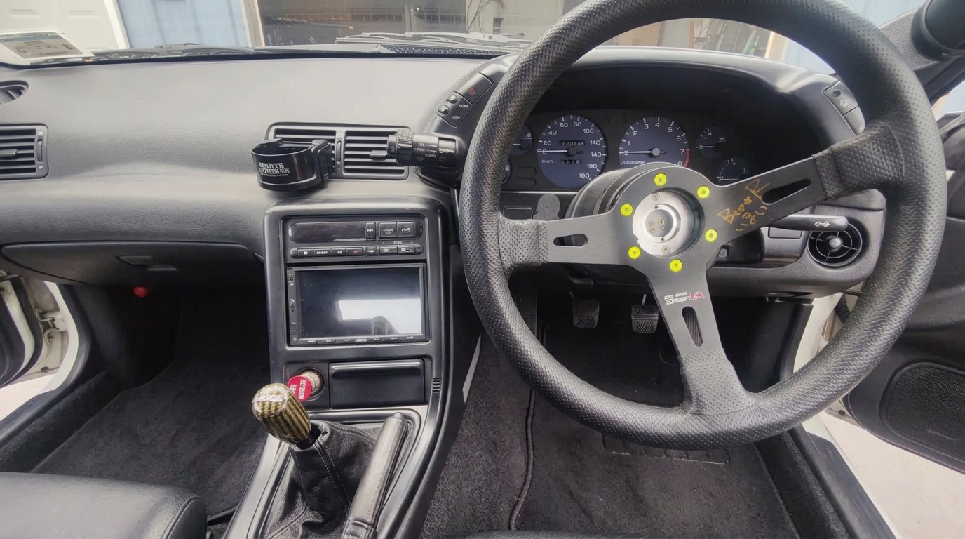 Right-hand-drive Nissan Skyline interior with aftermarket steering wheel